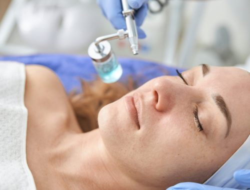 Professional cosmetologist is doing procedures for client in light cabinet